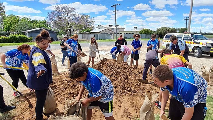 A group of students putting sand in a sandbag