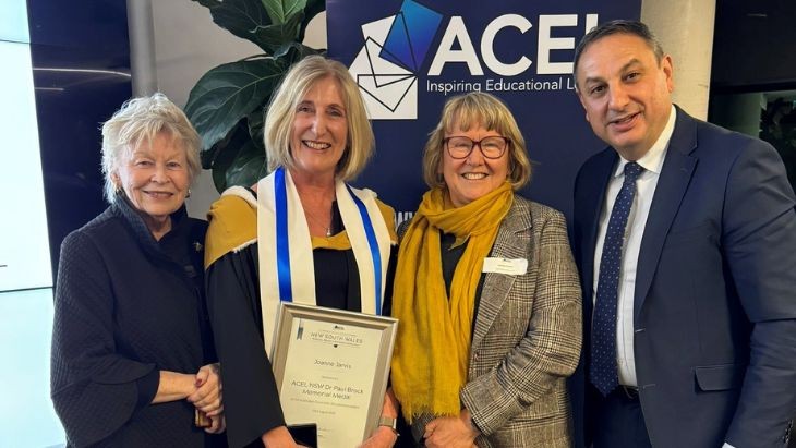 A woman holding a certificate with two other women and a man.