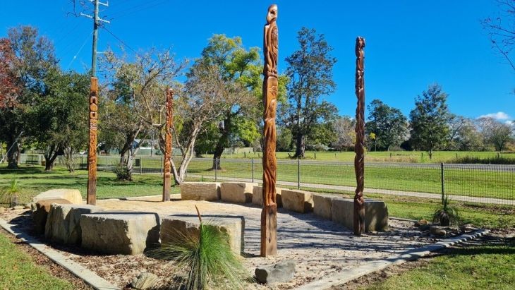 Four totem poles around a circle created with sandstone blocks.