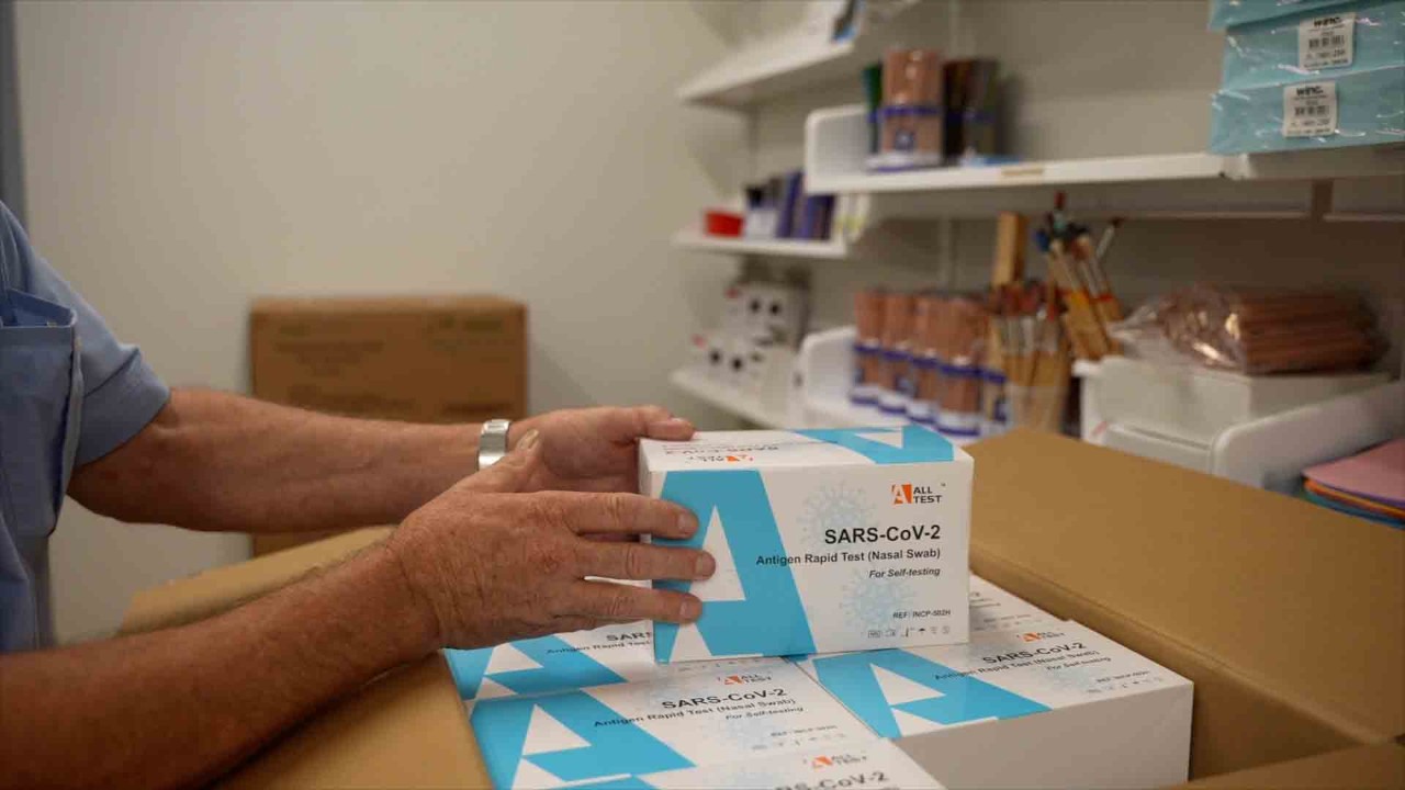 Handling a pack of rapid antigen test kits