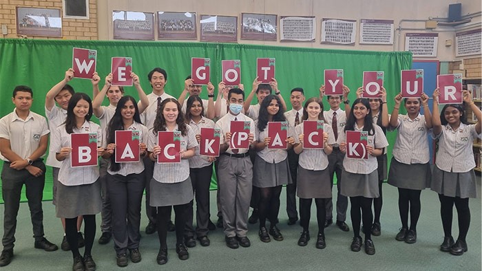 A group of students holding a sign that says we have got your backpack