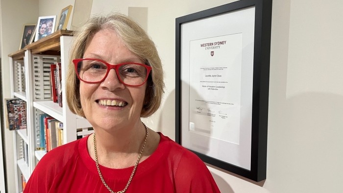 An older woman in red glasses smiling at the camera