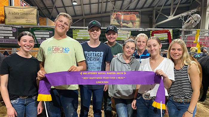 A group of young people holding a large show ribbon.