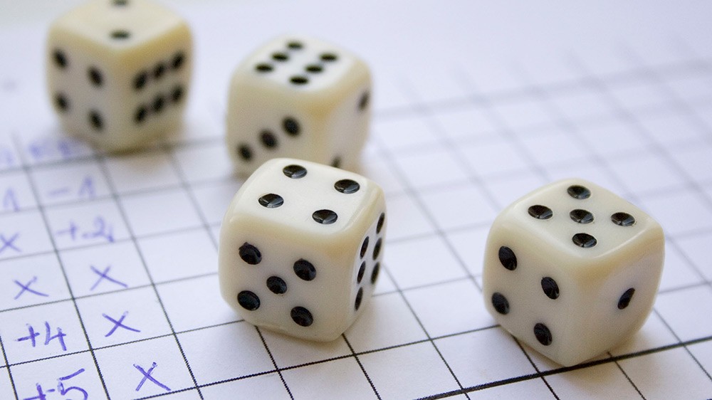 Four dice on a piece of paper with gridlines.