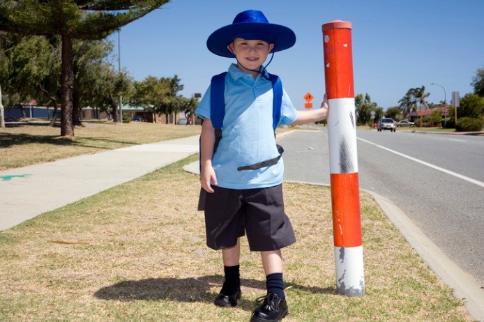Young student standing at road crossing