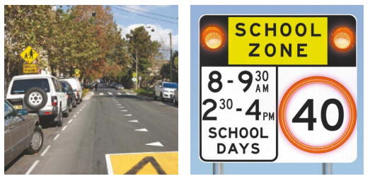 A school zone sign and a road outside a school.