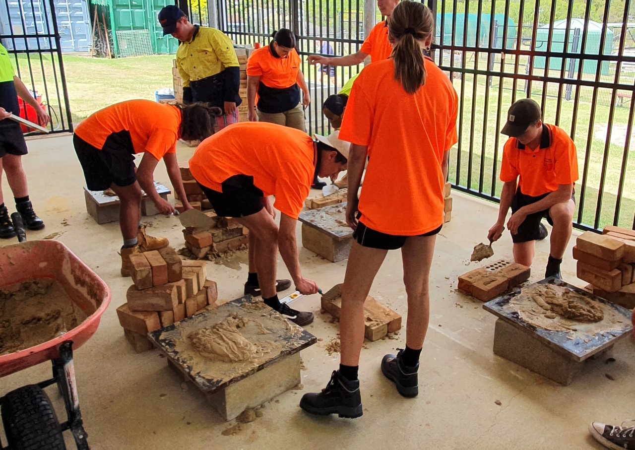 High school students learning bricklaying