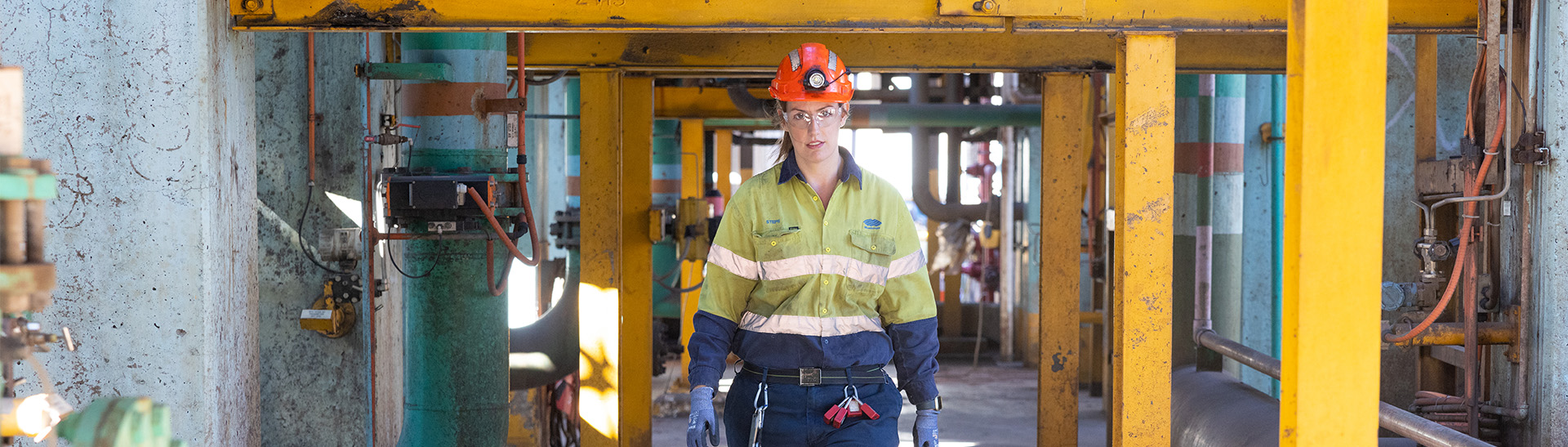 Female apprentice walking towards the camera on a construction site. 
