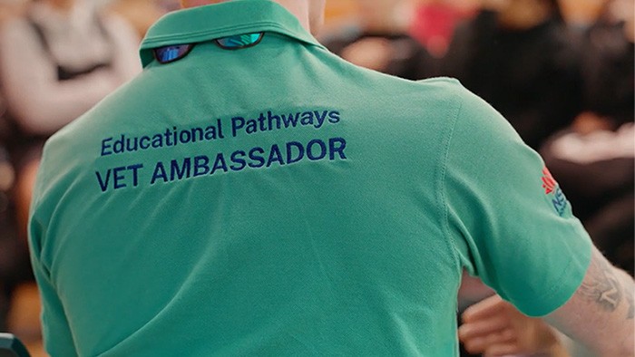 The back of a green polo shirt worn by a VET ambassador, with embroided words saying 'Educational Pathways VET Ambassador.'