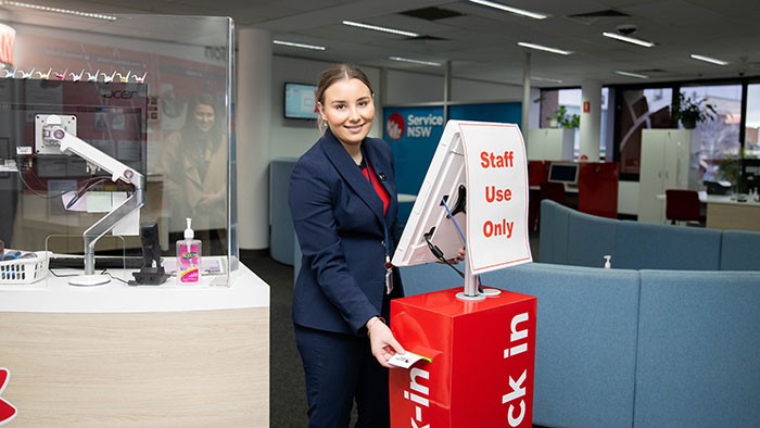 VET graduate Sophia standing at the check-in Service NSW Goulburn office kiosk