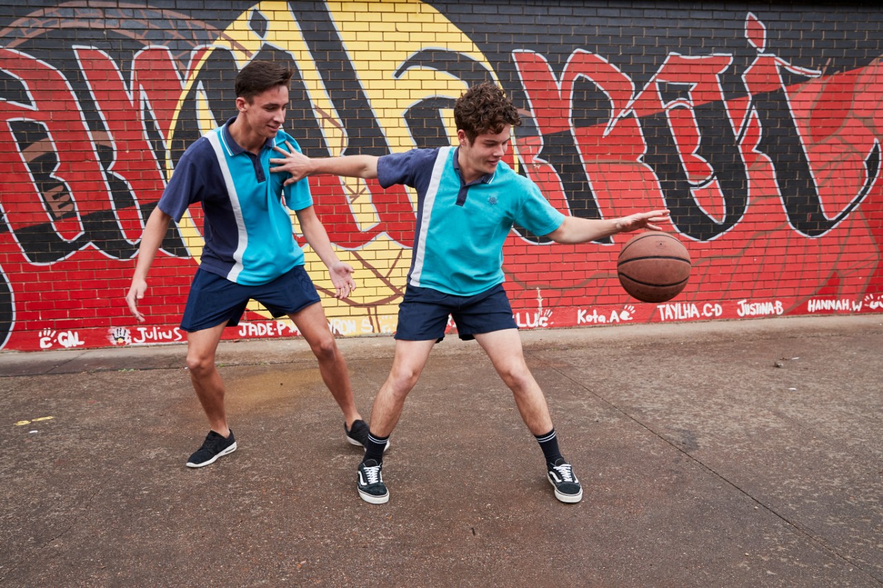 Two high school students playing basketball