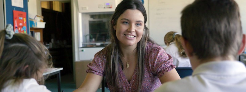 Female teacher smiling at student