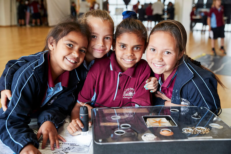 Four_primary_students_around_a_glass_case_of_artefacts