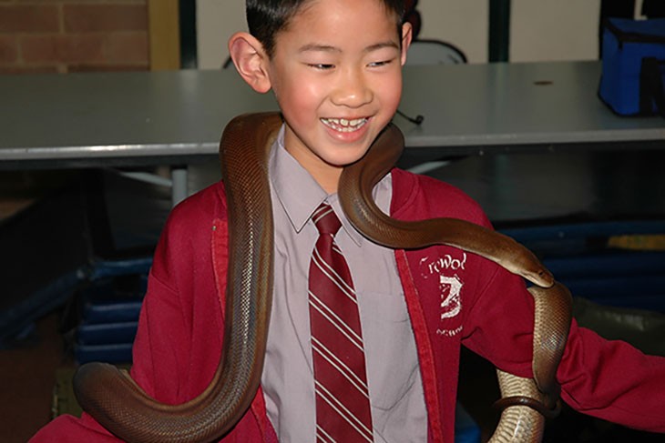 young male student handling a python