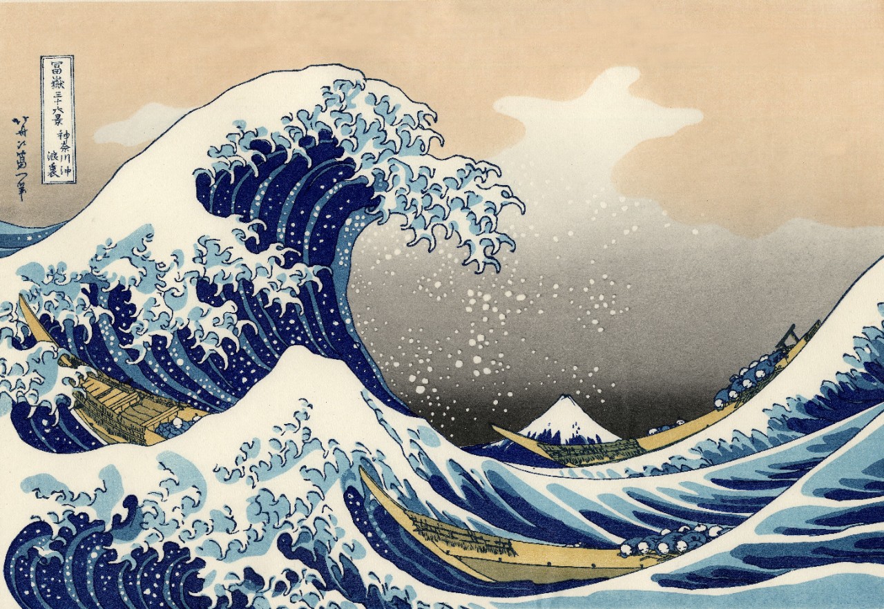 Japanese artwork showing a large wave about to crash on a small mountain, with three long boats in the water riding the waves..
