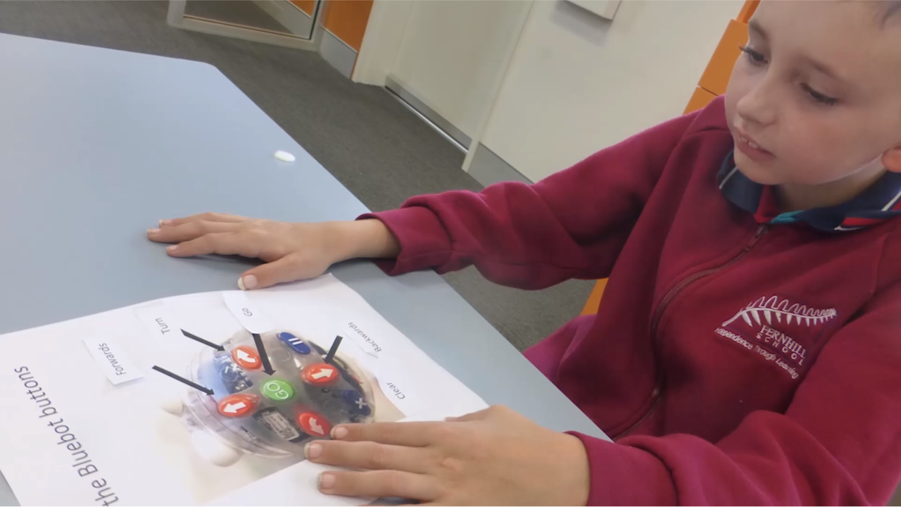 A child labels an image of a Beebot coding robot