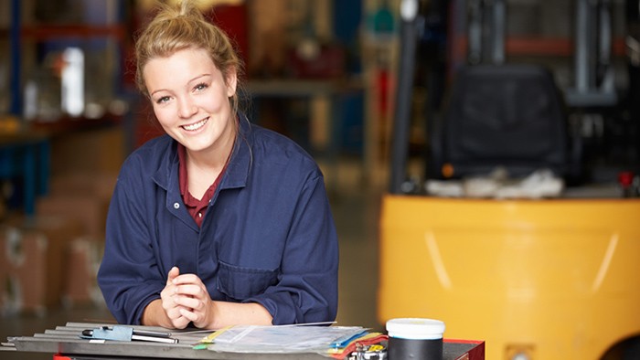 Female apprentice at desk smiling