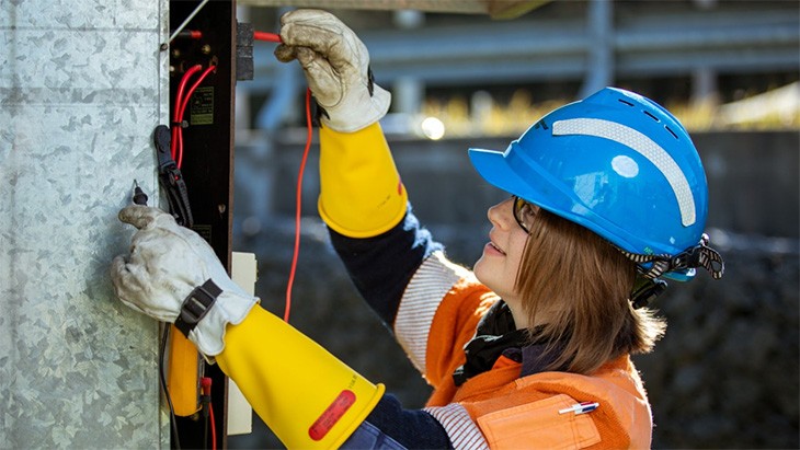 A female electrician working on switch box