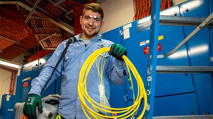 Male electronics apprentice with cables