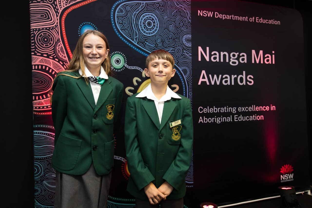 Female and Male student standing in front of banner