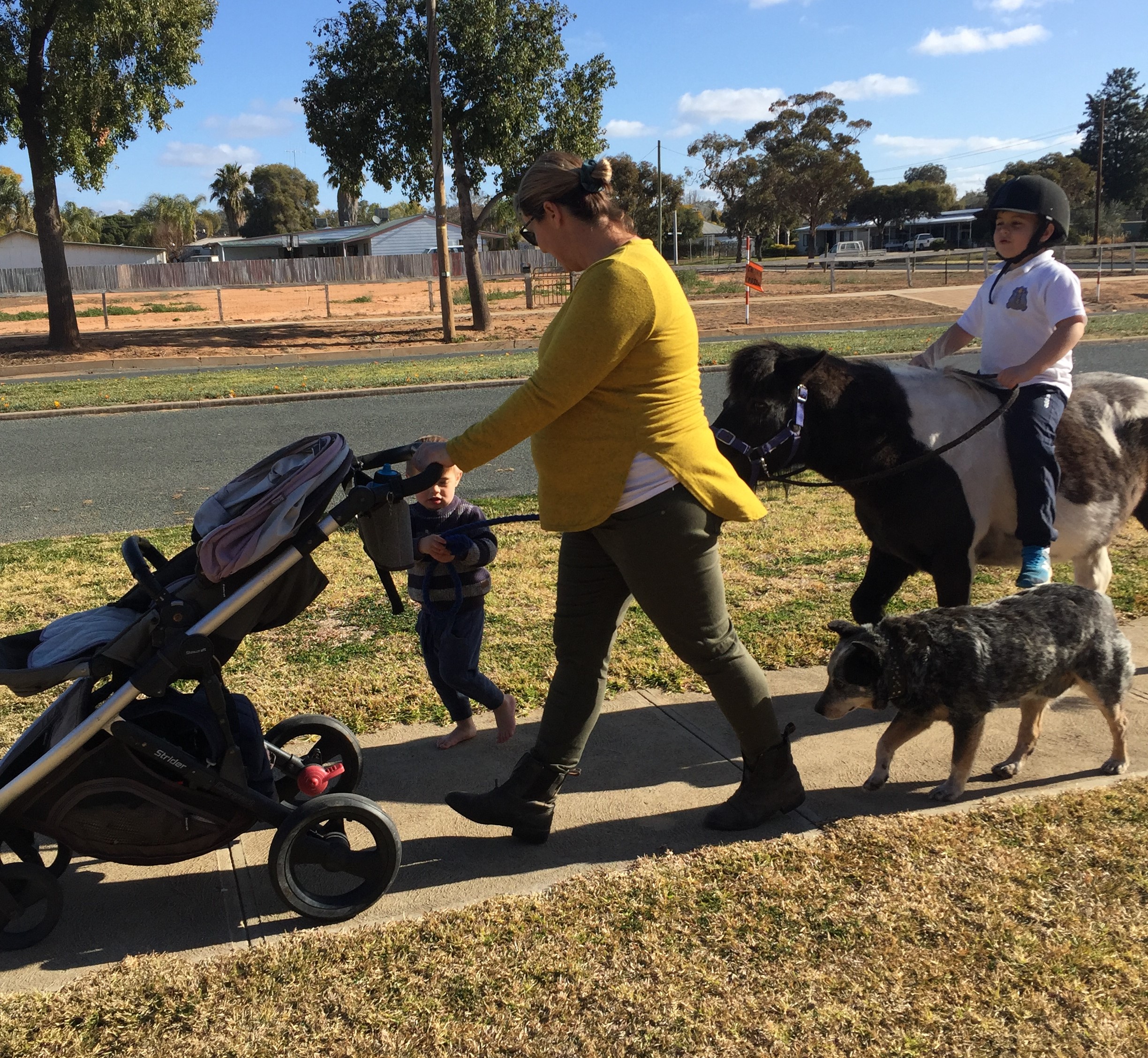 Family walking to school with a pony and a dog