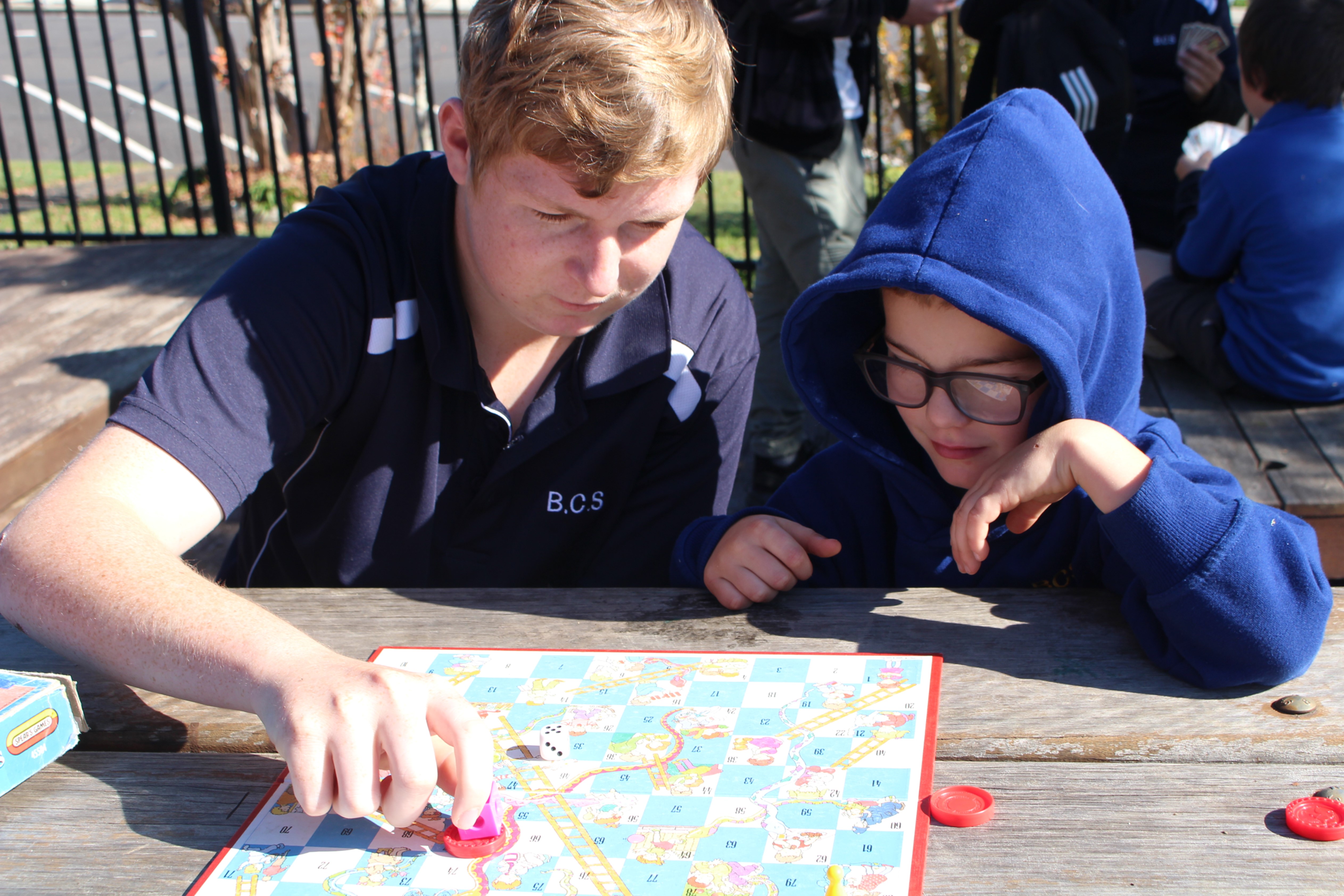 2 students playing snakes and ladders