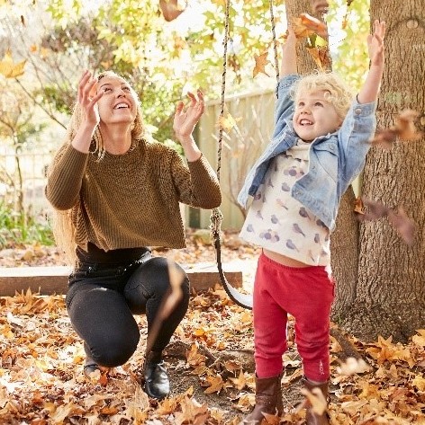 Woman and child throwing leaves in the air