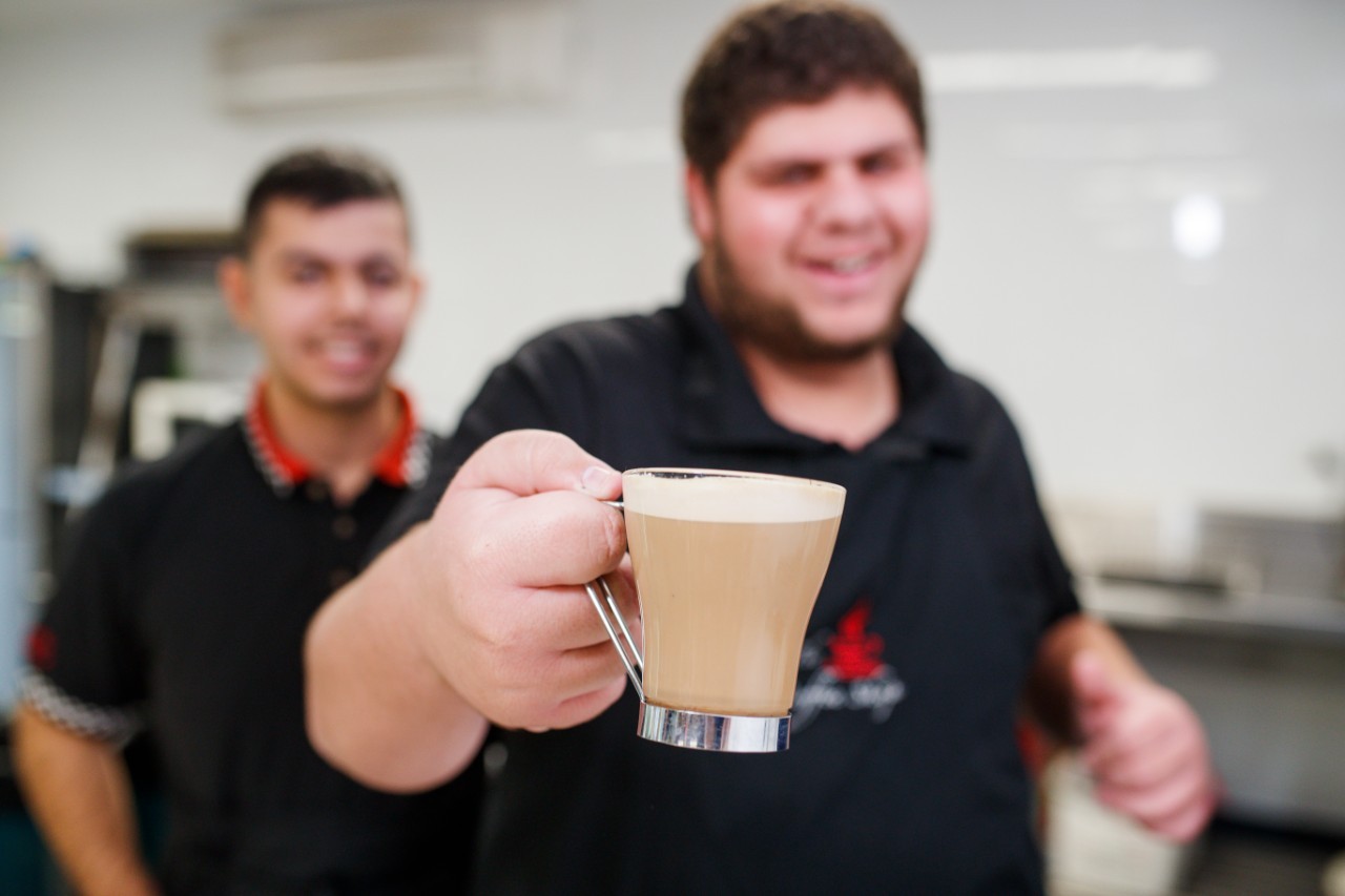 Hospitality student smiling with a coffee