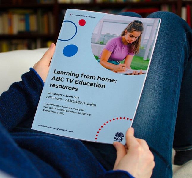 Person holding a printed booklet with the title "Learning from home: ABC TV Education resources".