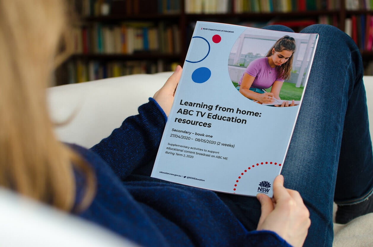 A woman reading the ABC TV Education resources secondary booklet.