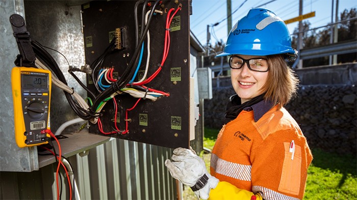 Female apprentice electrician testing circuits